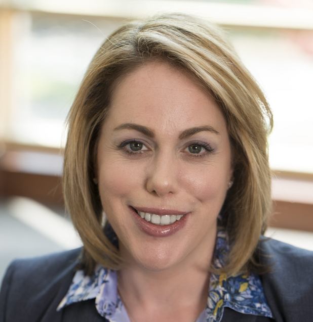 Professional woman smiling, dressed in business attire.